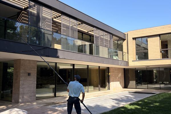 Trip's Windows crew member using extension pole to clean exterior windows